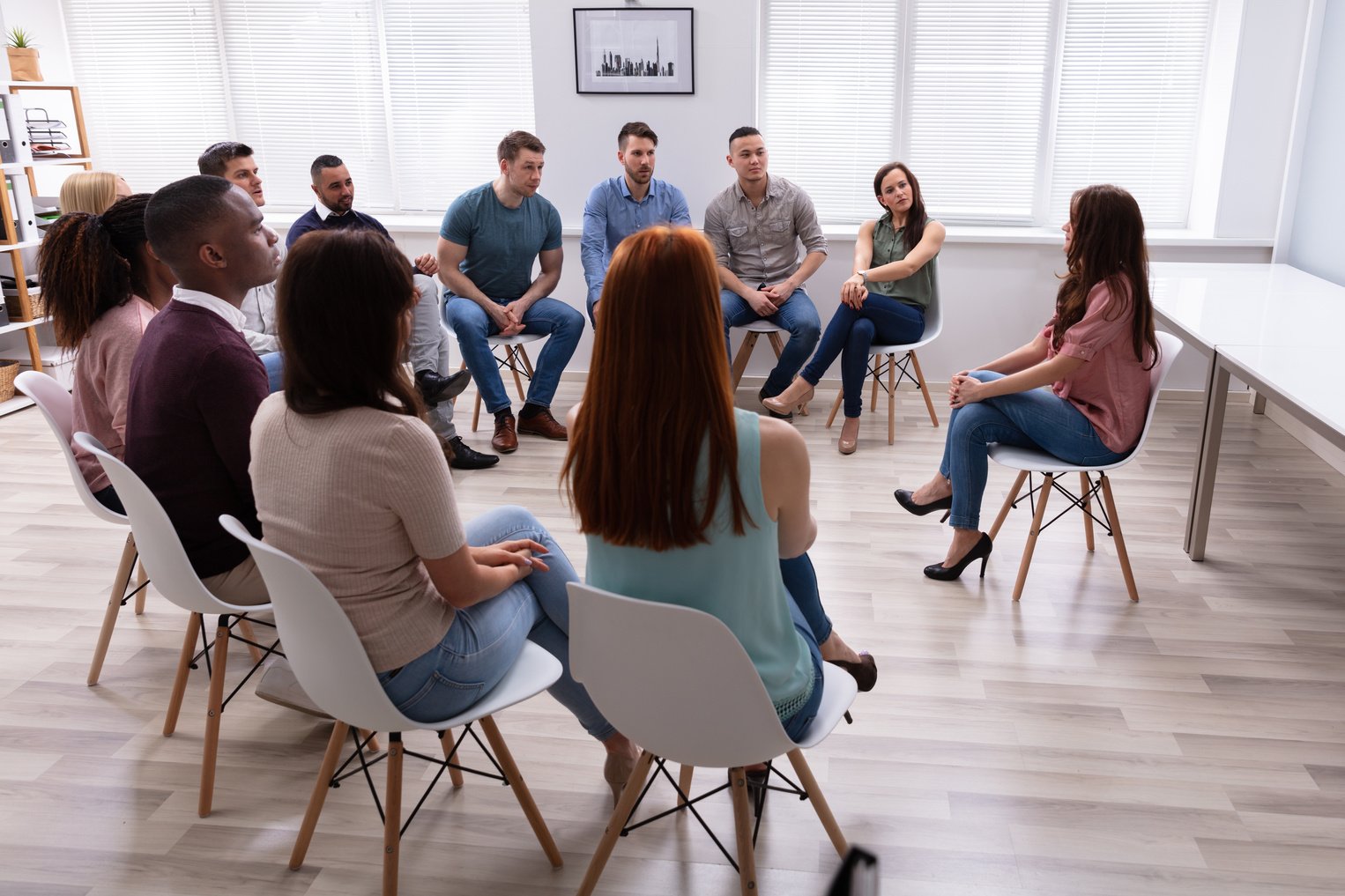 Female Therapist Speaking To Group At Therapy Section